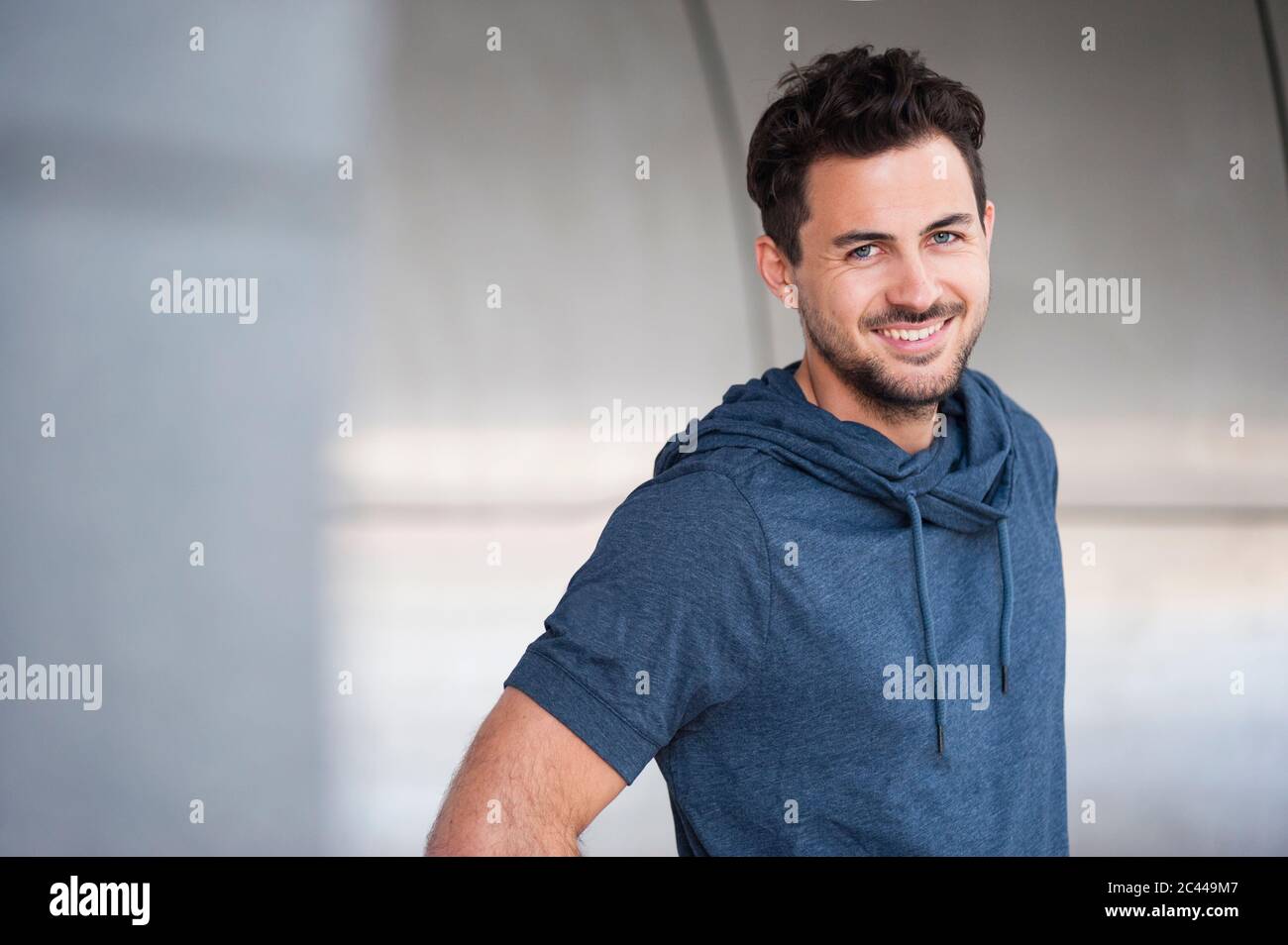 Portrait d'un jeune homme souriant regardant l'appareil photo Banque D'Images