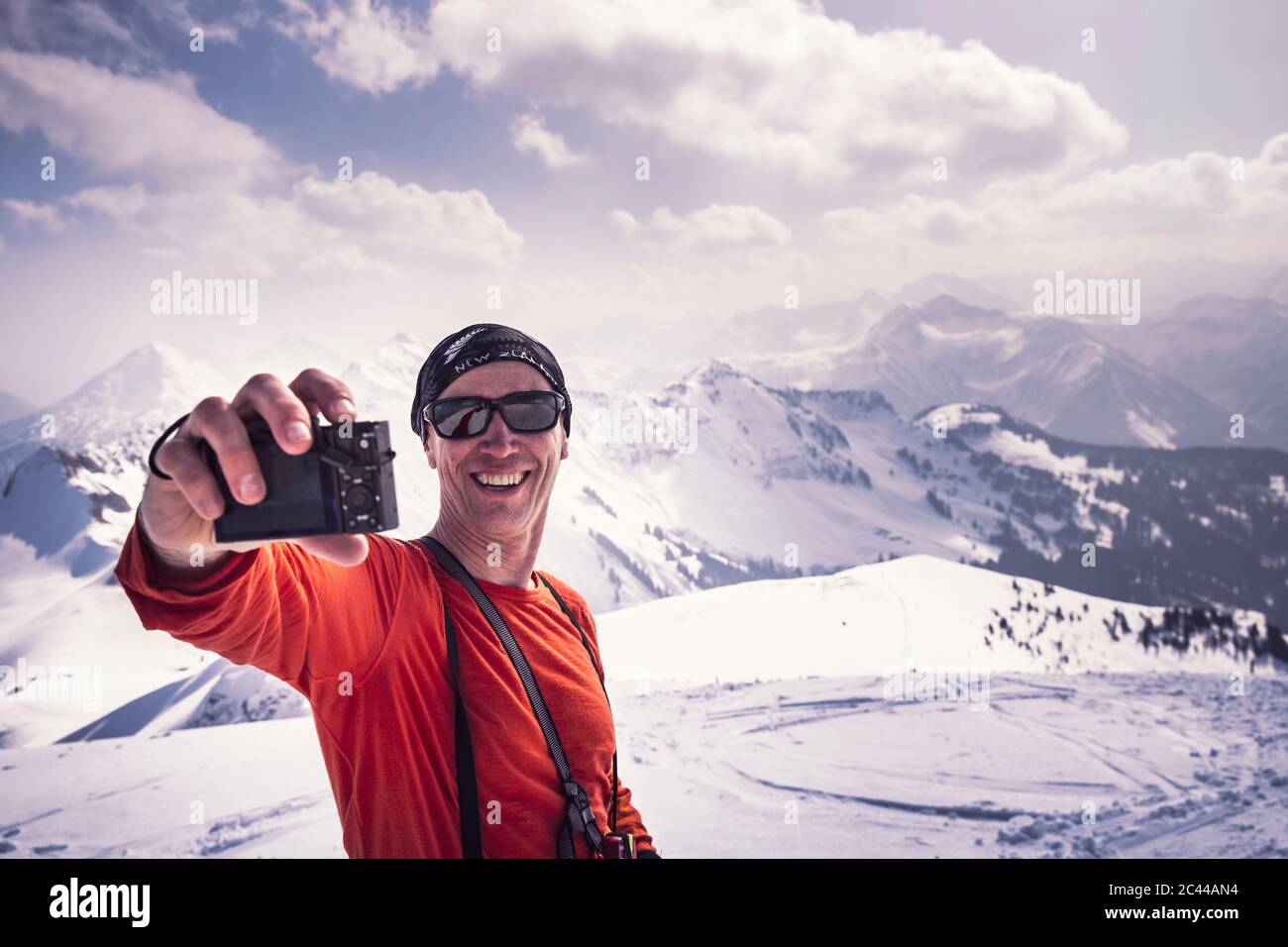 Heureux homme mature qui prend le selfie à travers la caméra tout en appréciant des vacances de ski à Achenkirch, Tyrol, Autriche Banque D'Images