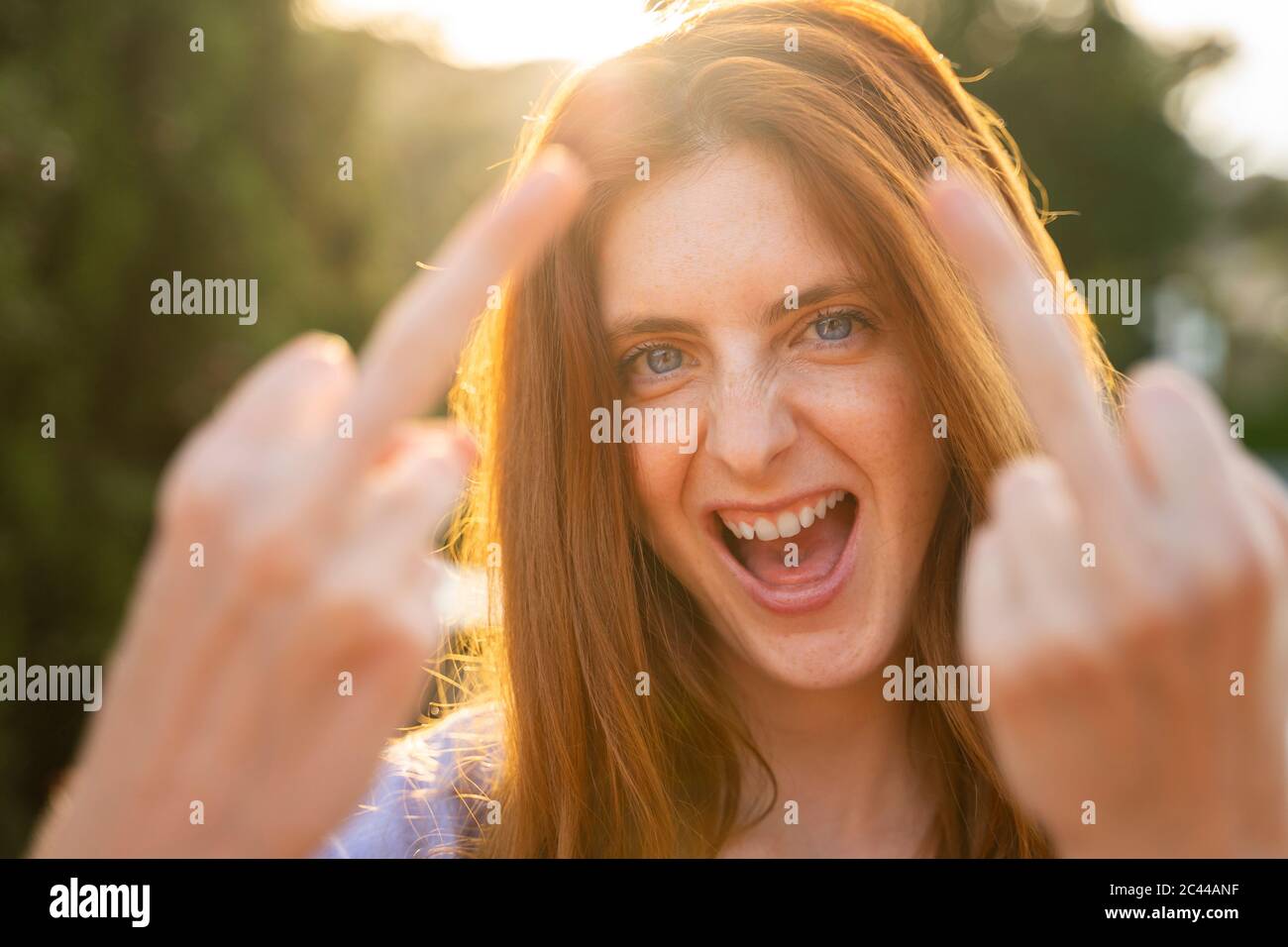 Portrait de la femme rieuse redirigée donnant le doigt Banque D'Images