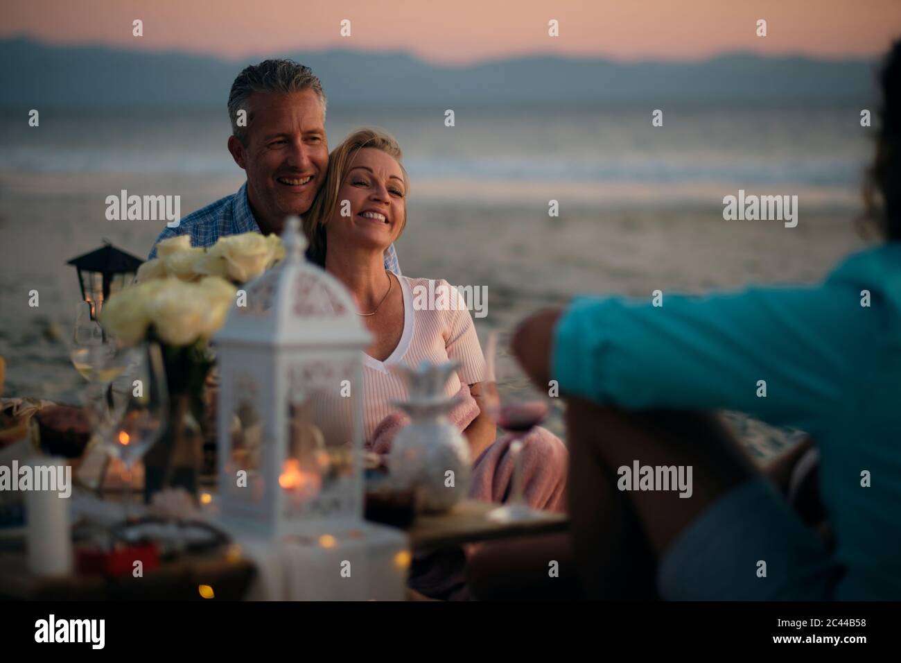 Les adultes qui profitent d'un dîner-fête au coucher du soleil sur la plage, Riviera Nayarit, Mexique. Banque D'Images