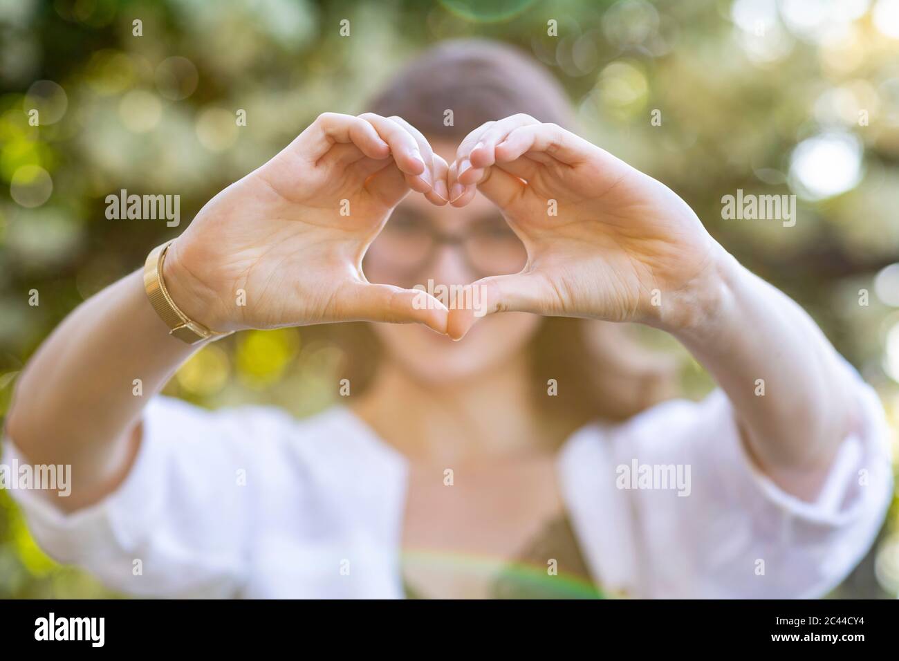 Jeune femme formant un cœur avec ses mains Banque D'Images