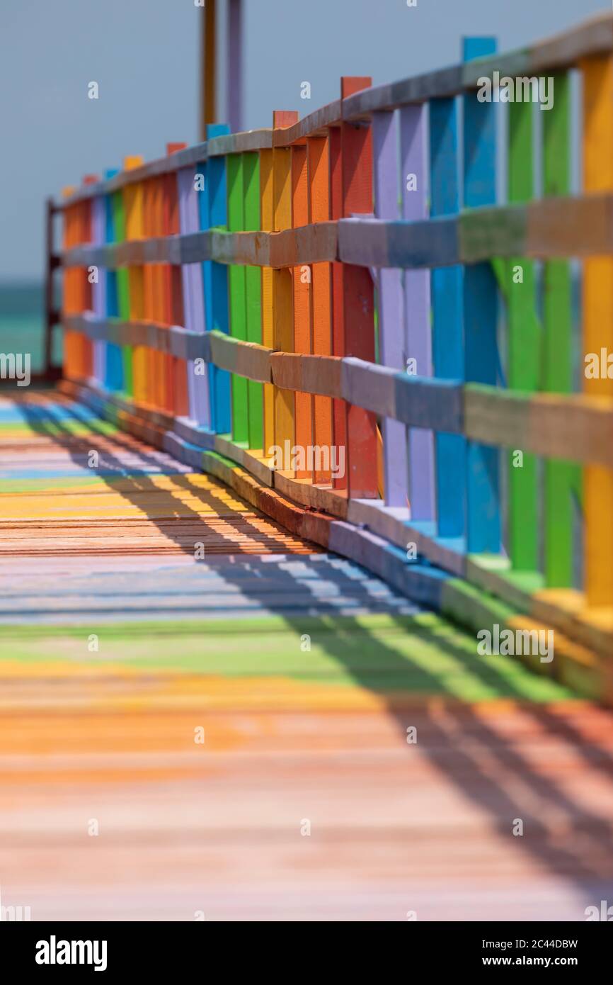 Promenade en bois décorée dans des couleurs vives et variées, face à la mer et parmi les mangroves, dans la ville de Wakai, dans les îles Togean, Indo Banque D'Images