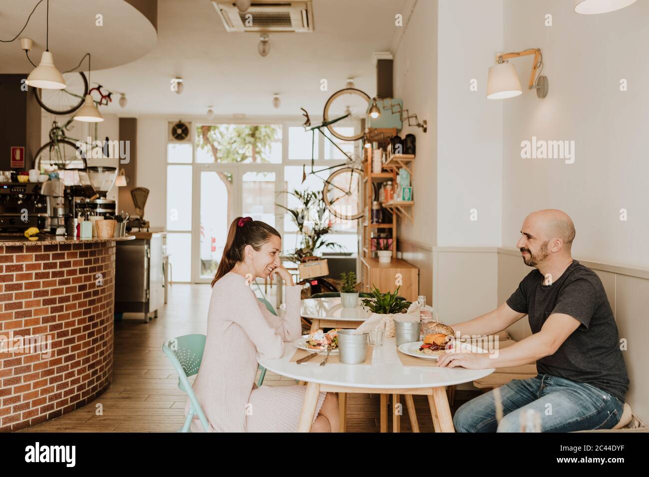Homme et femme souriants assis à une table dans un café Banque D'Images