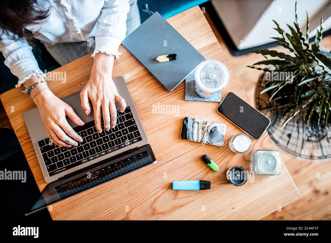Vue rognée d'une jeune femme travaillant sur un ordinateur portable à la maison, vue du dessus Banque D'Images Vue rognée d'une jeune femme travaillant sur un ordinateur portable à la maison, vue du dessus Banque D'Images