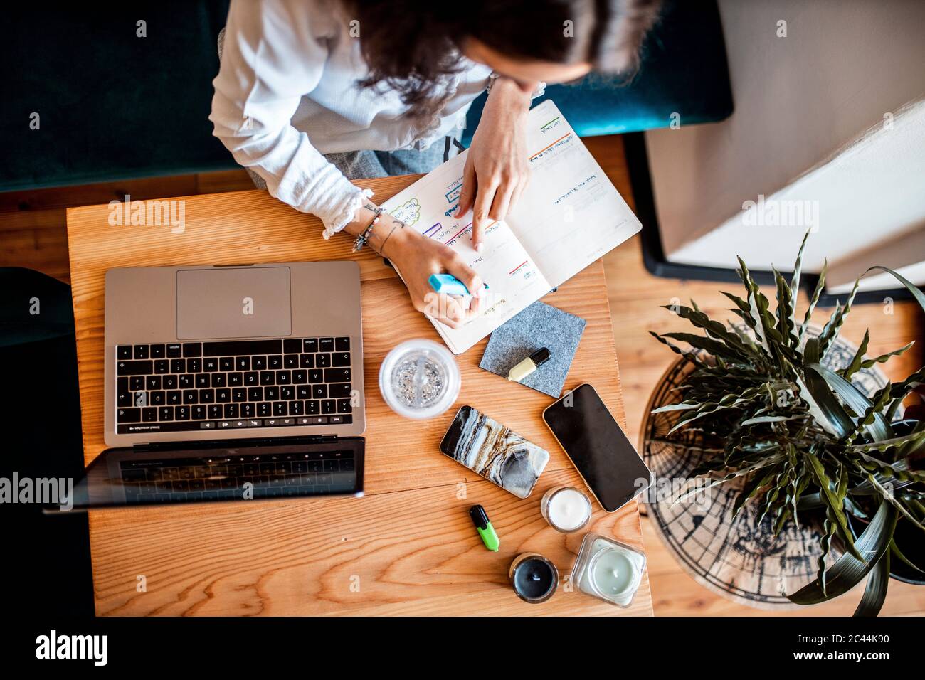 Vue rognée de la jeune femme travaillant à domicile, vue du dessus Banque D'Images Vue rognée de la jeune femme travaillant à domicile, vue du dessus Banque D'Images