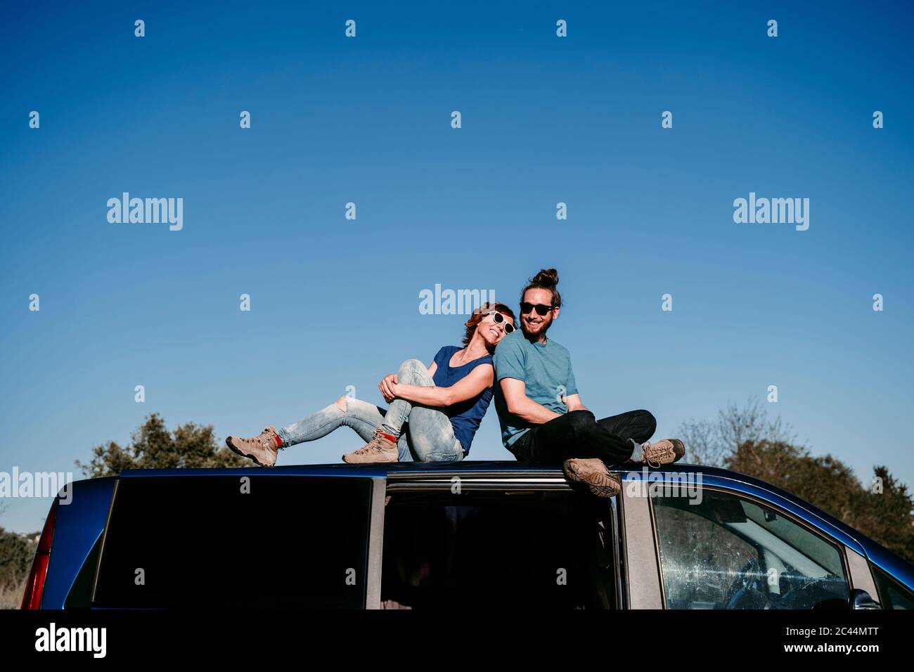 Heureux homme assis sur le toit d'une voiture Banque de photographies ...