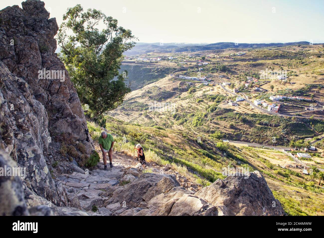 Espagne, Canaries, La Gomera, deux randonneurs ordre croissant avec la Montagne de la Table Mountain Village en arrière-plan Banque D'Images