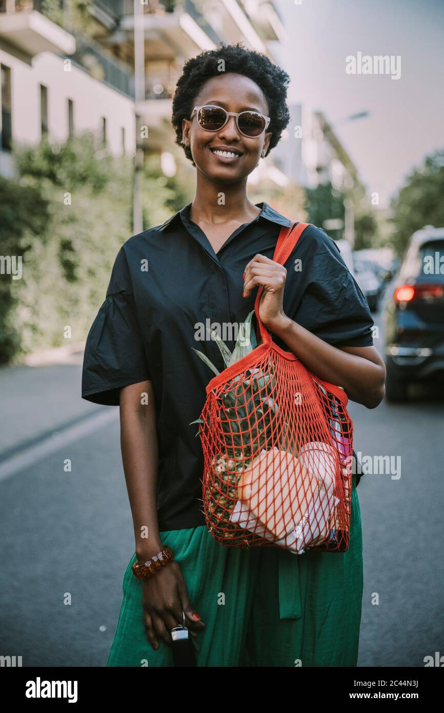 Portrait de jeune femme souriante debout dans la rue avec son achat Banque D'Images