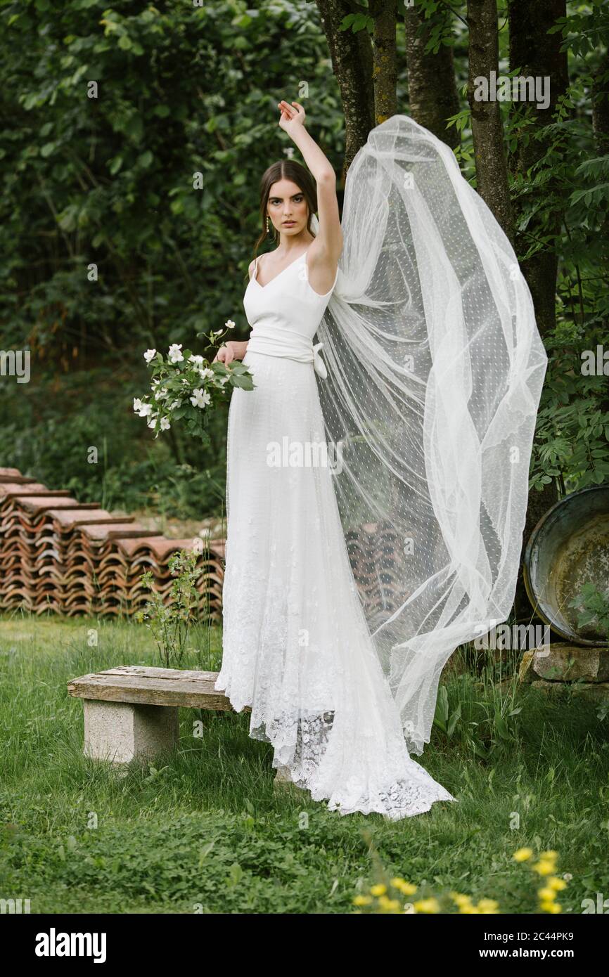 Jeune femme en robe de mariage élégante et bouquet Banque D'Images