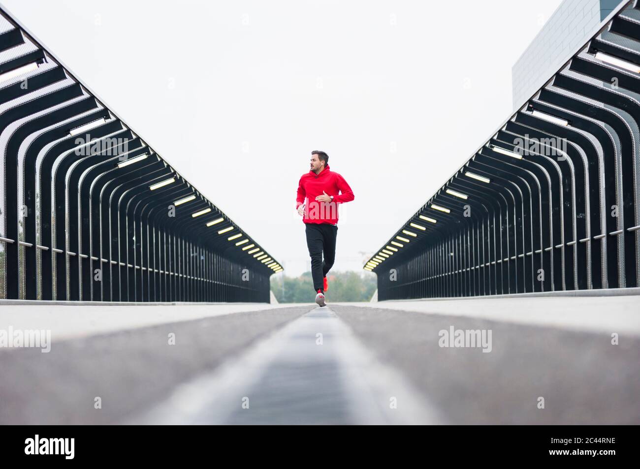 Jeune homme qui court sur un pont Banque D'Images