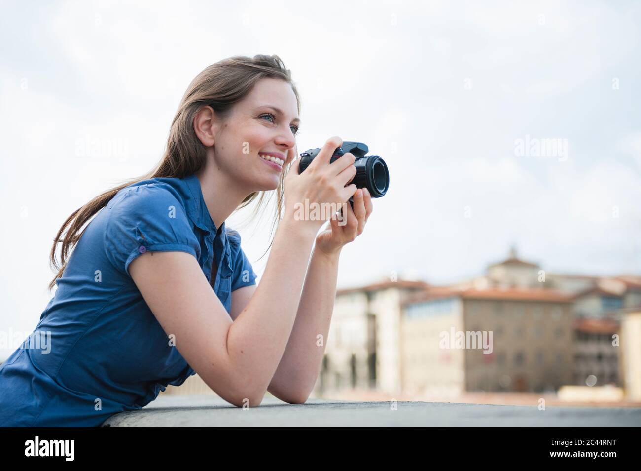 Portrait d'une femme heureuse prenant des photos avec un appareil photo numérique, Florence, Italie Banque D'Images