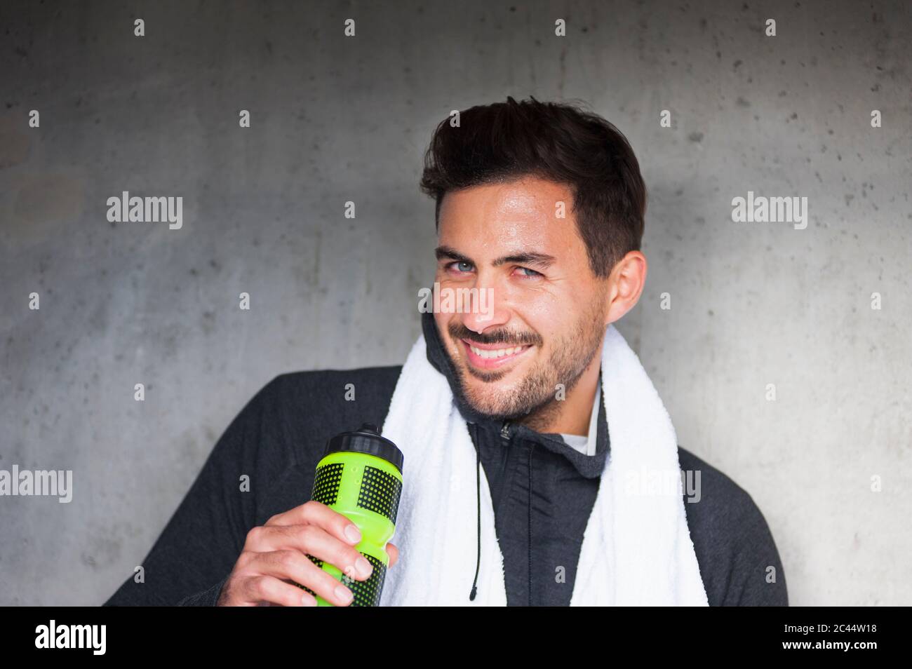 Portrait d'un jeune homme souriant ayant une pause de l'entraînement Banque D'Images