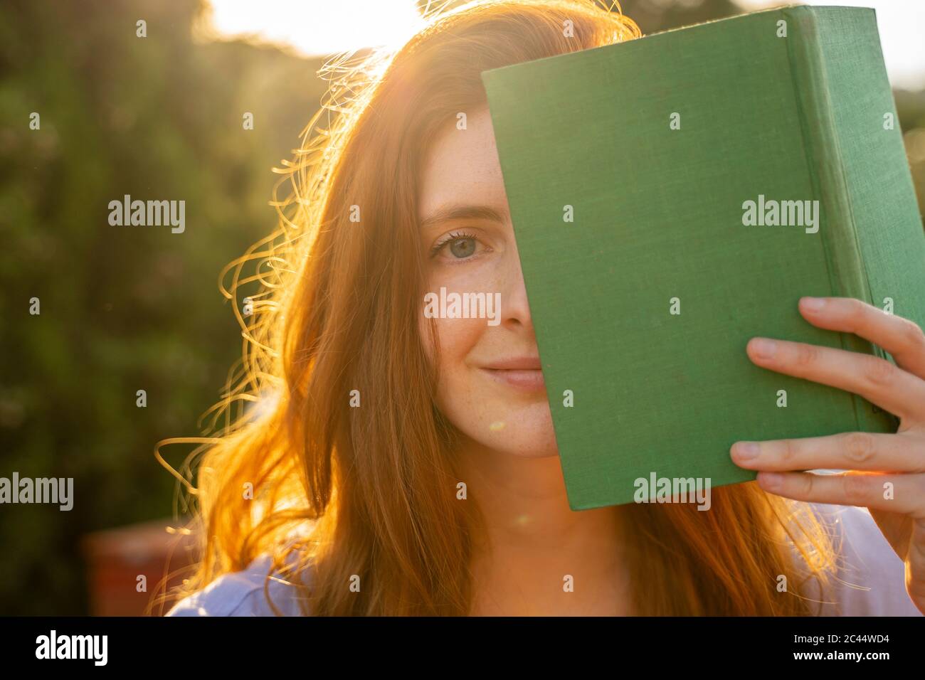 Portrait d'une femme à tête rouge avec livre vert Banque D'Images