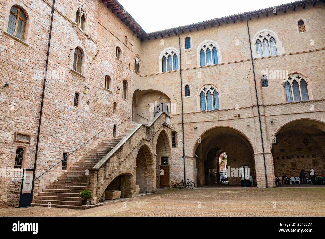 1 juin 2019 - Foligno, Pérouse, Ombrie, Italie - la cour intérieure et l'escalier gothique de l'ancien palais Trinci. Mur de briques, fenêtres, arches et Banque D'Images