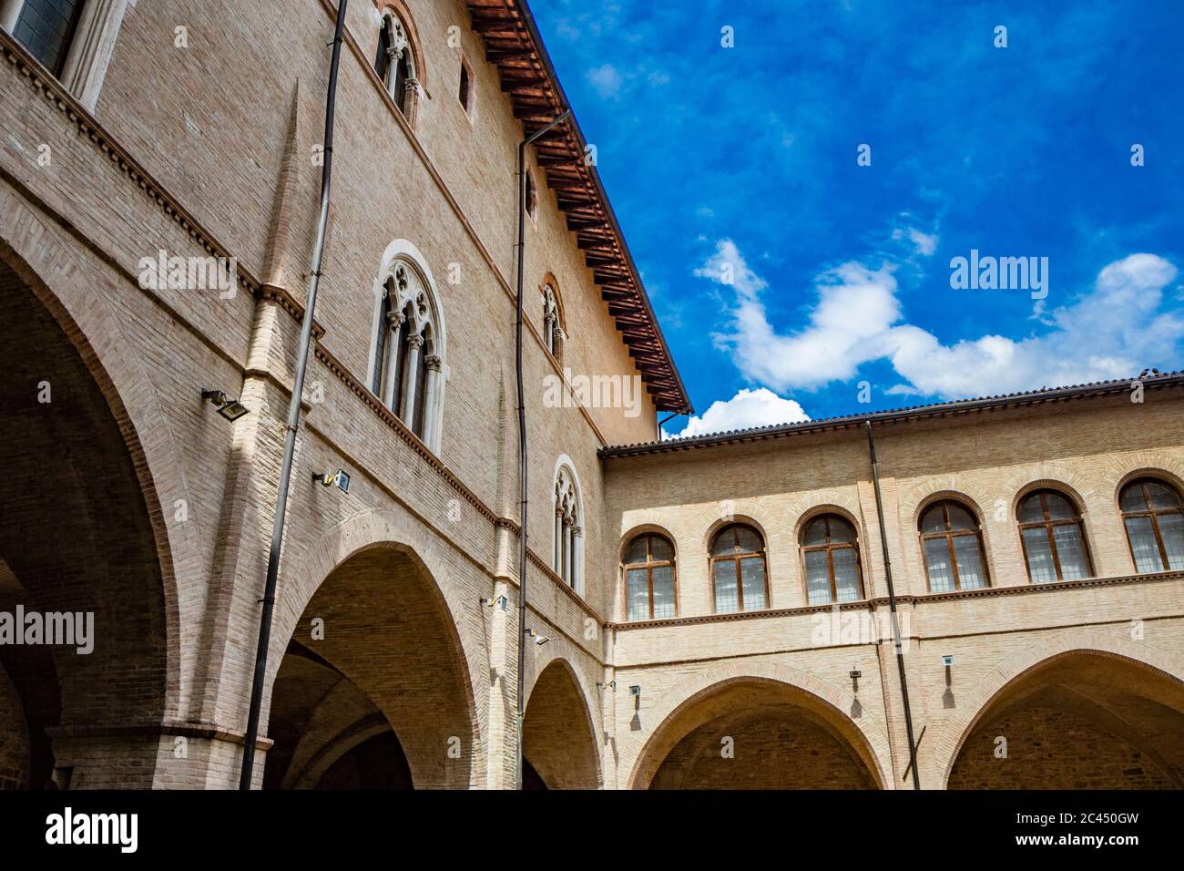 1 juin 2019 - Foligno, Pérouse, Ombrie, Italie - la cour intérieure et l'escalier gothique de l'ancien palais Trinci. Mur de briques, fenêtres, arches et Banque D'Images