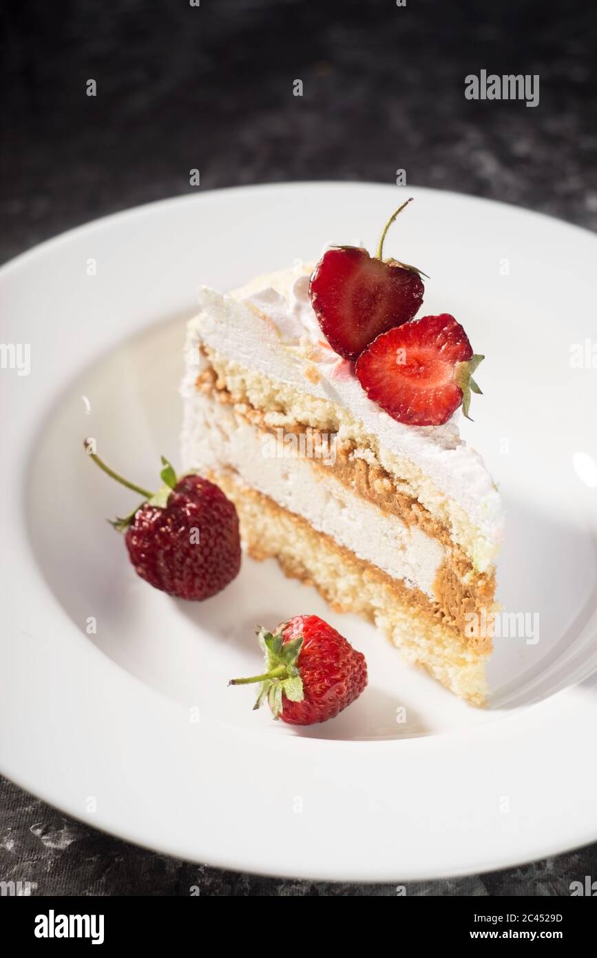 Un Morceau De Gateau Delicat Avec Des Tranches De Fraises Sur Une Assiette Blanche Sur Fond Blanc Et Gris Photo Stock Alamy