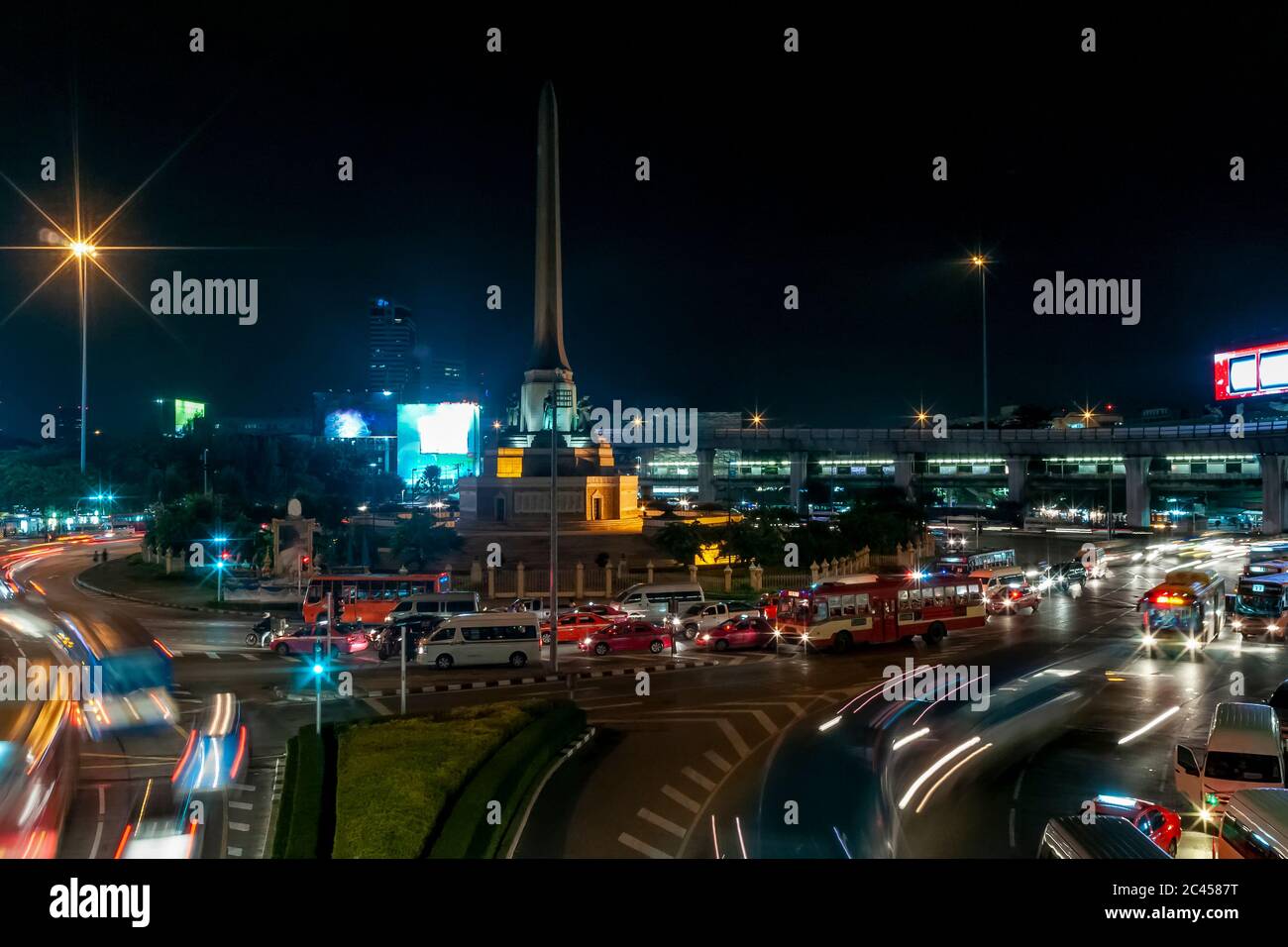 Vue nocturne du monument de la victoire dans le quartier Ratchathewi de Bangkok, en Thaïlande, avec beaucoup de circulation au rond-point Banque D'Images