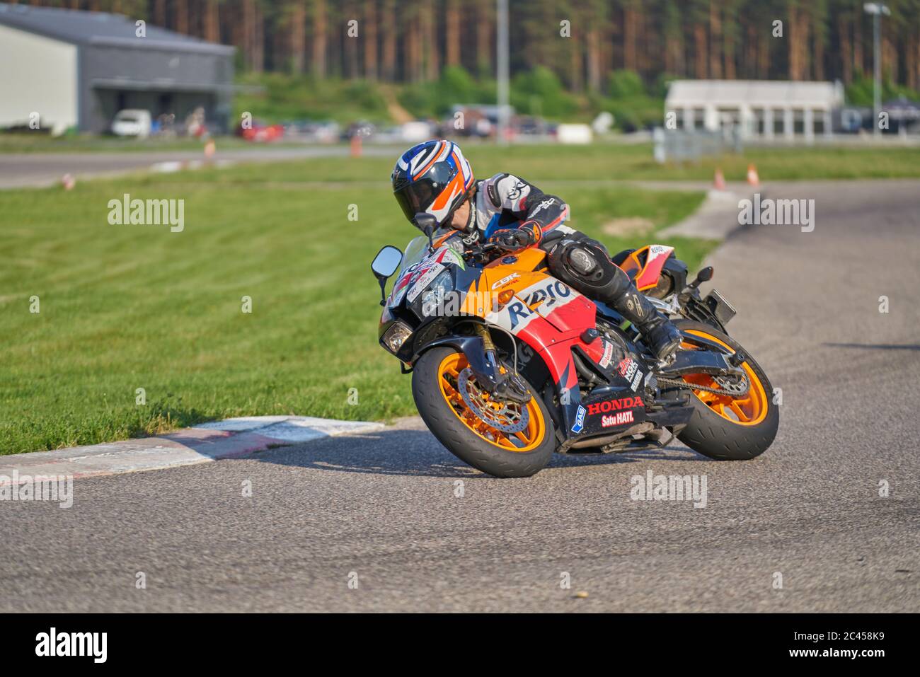 12-06-2020 Riga, Lettonie. Pilote de moto dans un casque blanc et course d'équipement à grande vitesse sur piste de course avec flou de mouvement. Course sur le thème du sport. Banque D'Images