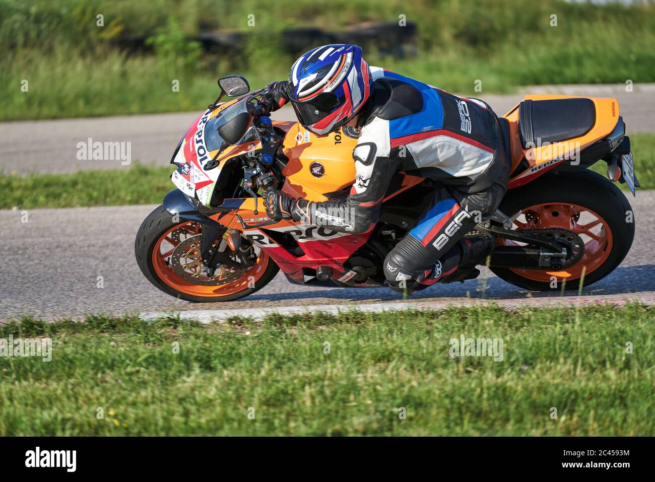 12-06-2020 Riga, Lettonie. Pilote de moto dans un casque blanc et course d'équipement à grande vitesse sur piste de course avec flou de mouvement. Course sur le thème du sport. Banque D'Images