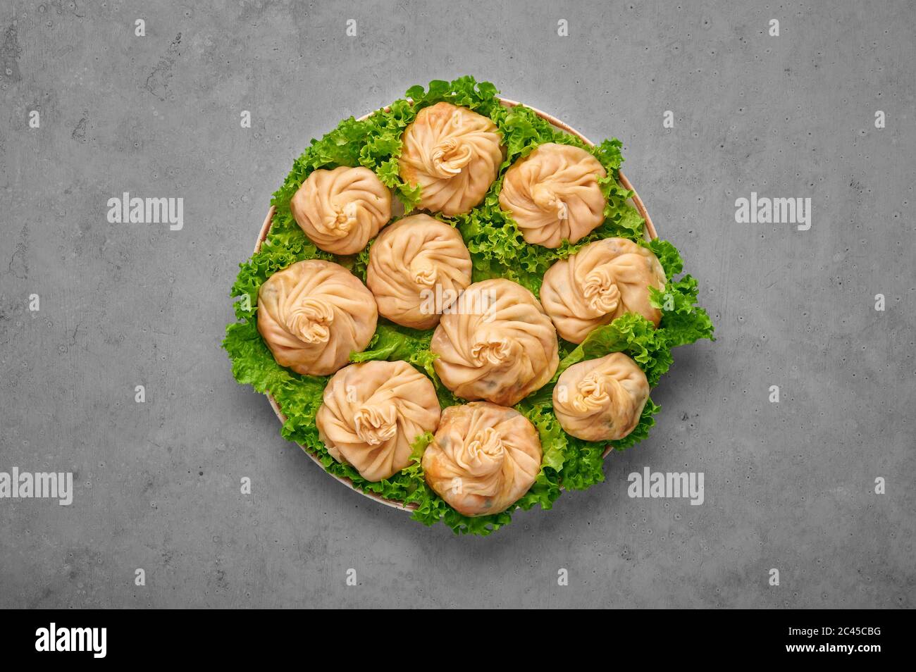Veg Momos sur table en béton gris . Momos est le plat populaire de cuisine indienne, tibétaine, chinoise. Cuisine asiatique. Repas végétarien. Vue de dessus Banque D'Images