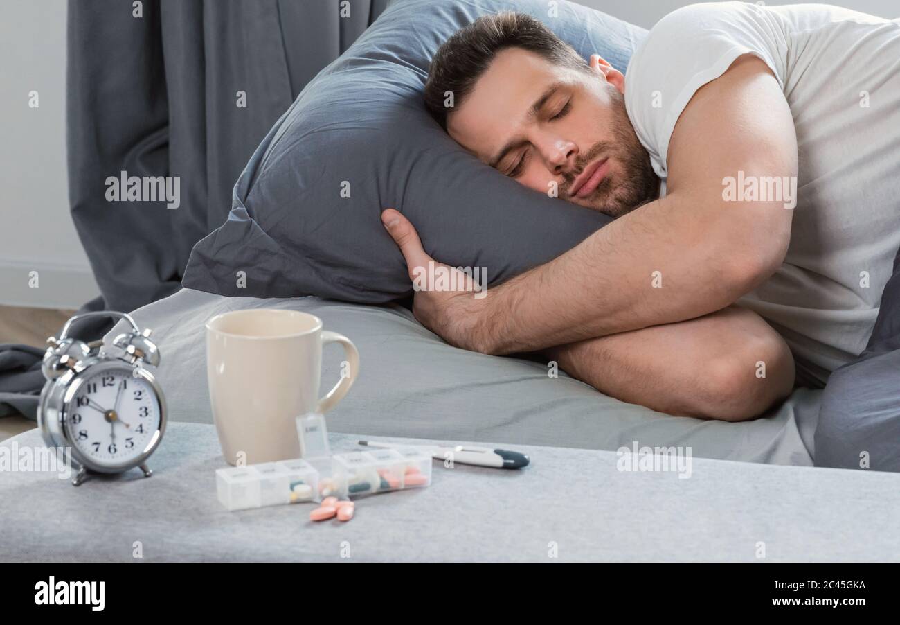 Malade Homme endormi ayant de la fièvre couché dans le lit à la maison Banque D'Images