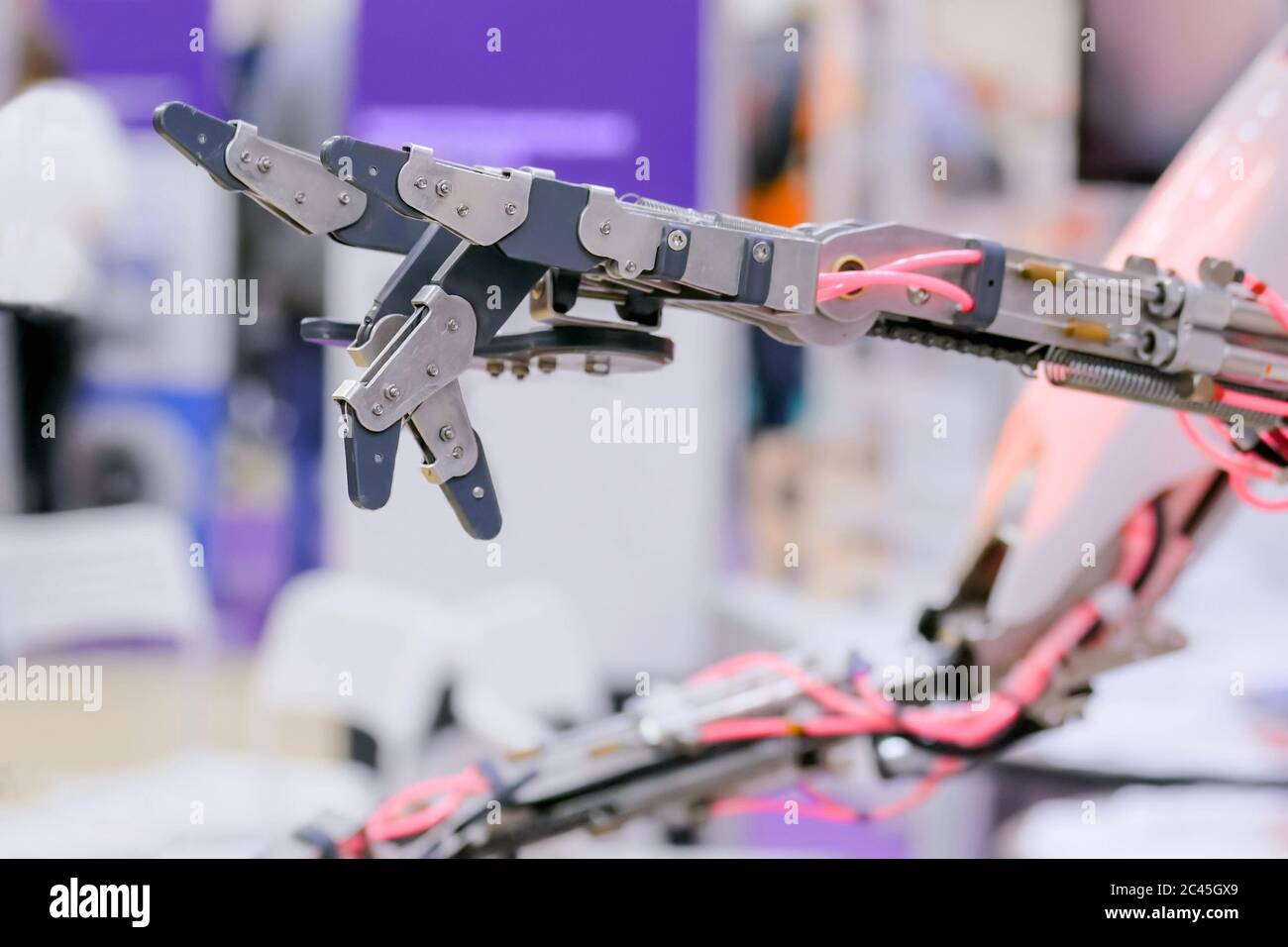 Gros plan de la main robotique futuriste montrant les cornes du diable panneau métal rock symbole geste à l'exposition de technologie. Avenir, science et robotique Banque D'Images