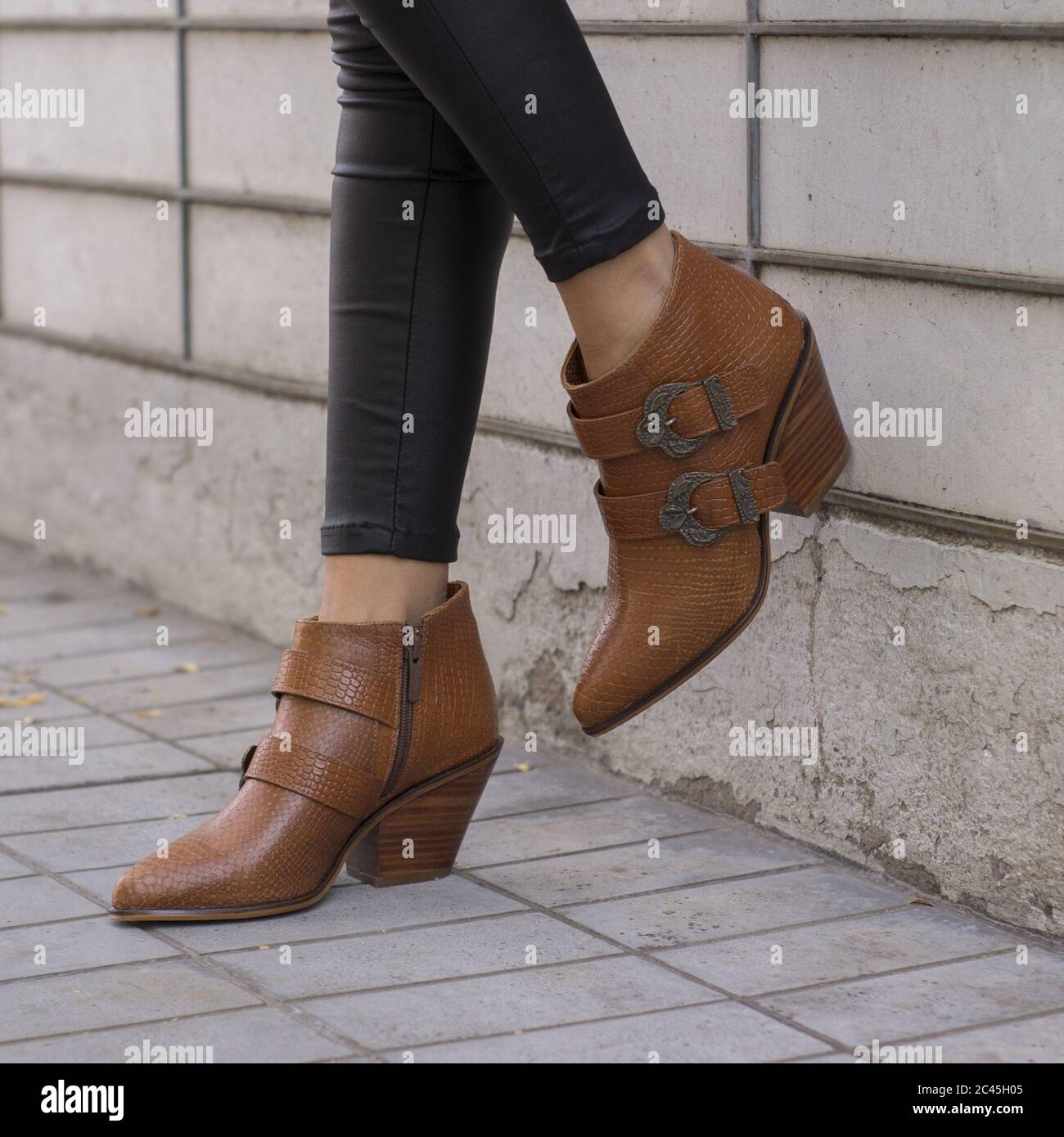 Femme tendance portant des talons à motifs crocodile marron élégants décorés avec courroies Banque D'Images