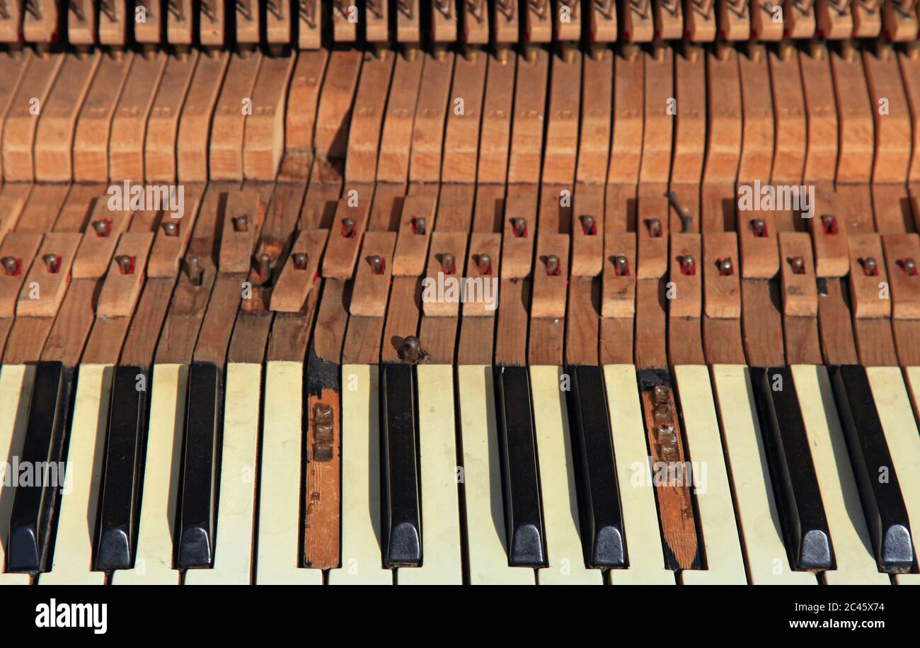 Un piano vieux et oublié dans un parc de la ville. Vue du clavier cassé et du mécanisme de marteau (fenger) du gros plan du piano de rue Banque D'Images