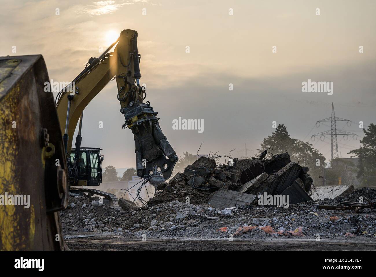 Destruction de bâtiments site de démolition Pelle hydraulique avec machine de concasseur hydraulique ruine maison. Banque D'Images
