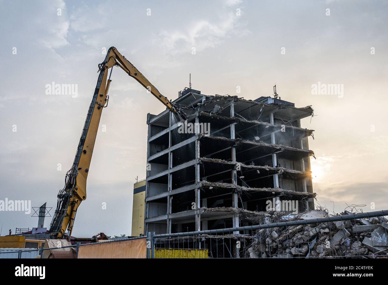 Bâtiment Maison démolition Pelle hydraulique avec site machine crasher et jaune contenant. Banque D'Images