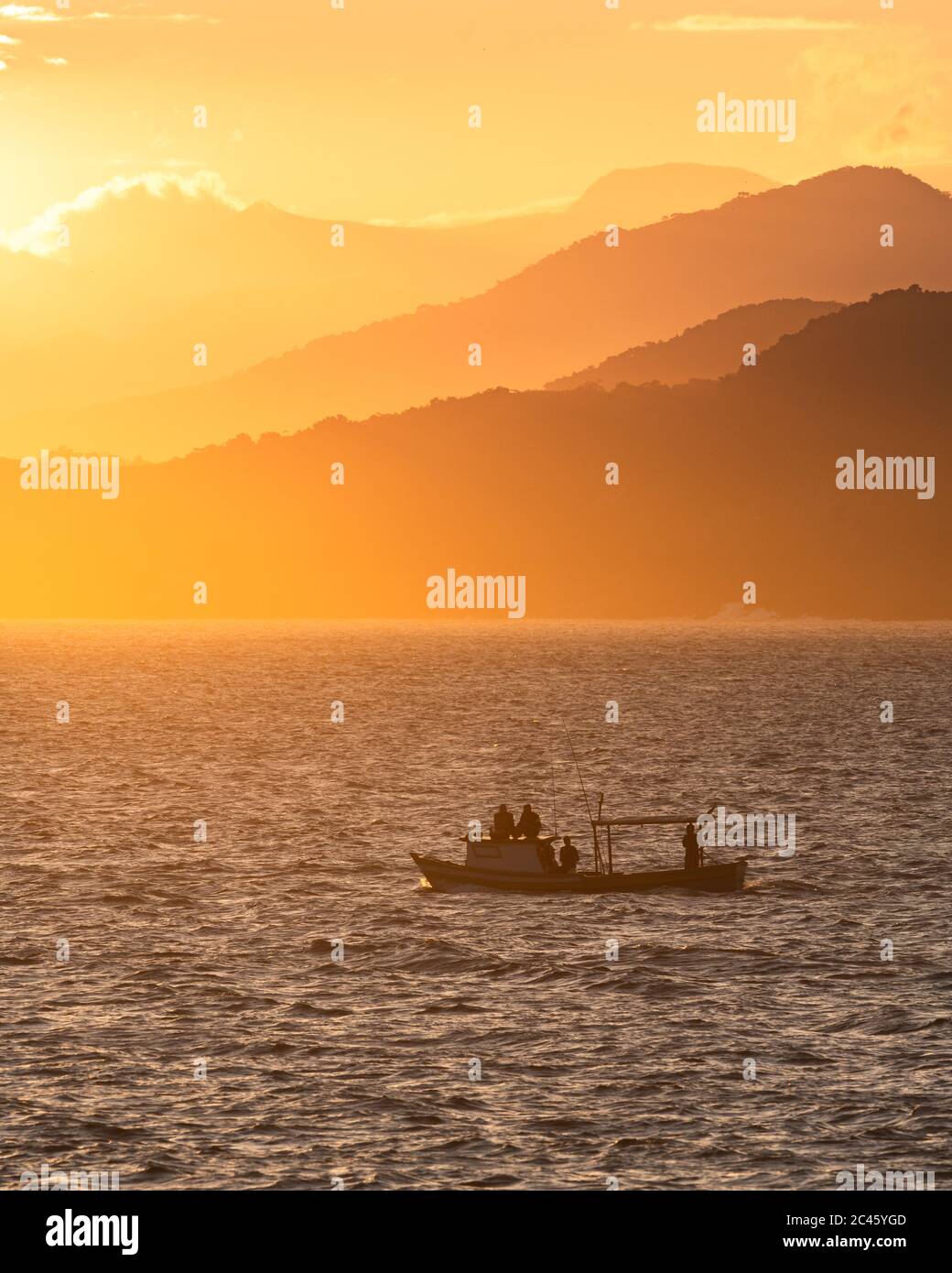Un bateau de pêche navigue à l'entrée sud du Canal de São Sebastião, au Brésil, au coucher du soleil Banque D'Images