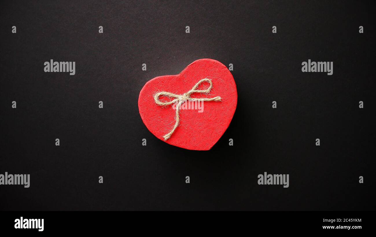 Saint Valentin en forme de coeur boîte-cadeau sur noir bacground. Banque D'Images