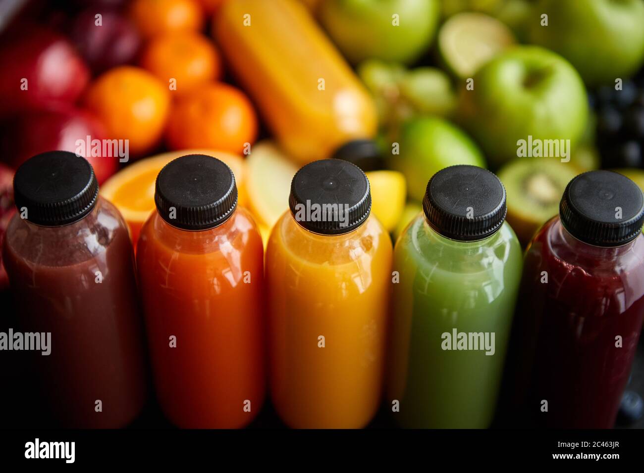 Bouteilles colorées remplies de jus de fruits et légumes frais ou de smoothie Banque D'Images