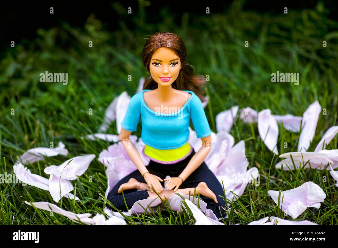 Tambov, Fédération de Russie - 12 juin 2020 poupée Brunette Barbie assise dans la posture de yoga lotus à l'extérieur Banque D'Images