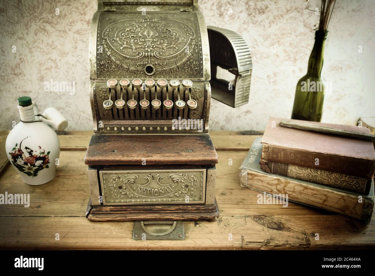 KOLMANSKOP,NAMIBIE -27 JANV. 2016: Caisse d'époque sur table en bois dans un bureau d'affaires de style rétro. Pot et tasse en argile, livres et verre non imprimés Banque D'Images