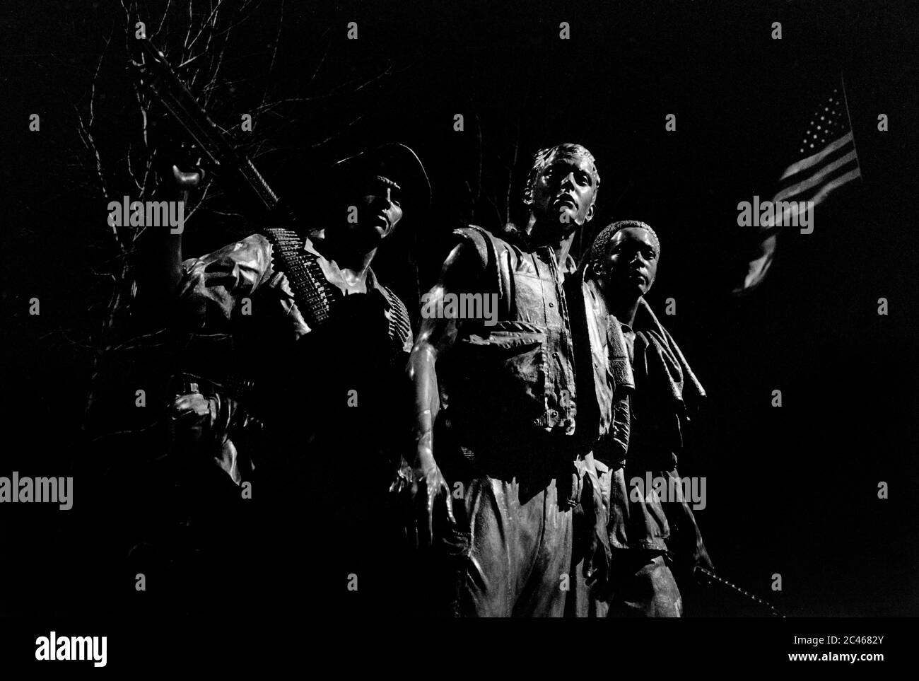 Vietnam Veterans Memorial Washington DC États-Unis 1988. Les trois militaires (les trois soldats) de Frederick Hart. Vu ici la nuit avec les étoiles et les rayures (la gloire ancienne) en arrière-plan. Les trois soldats (également connus sous le nom de trois militaires) sont une statue de bronze de Frederick Hart. Dévoilée le 11 novembre 1984 à la fête des anciens combattants[ dans le National Mall, elle fait partie du Vietnam Veterans Memorial commémorant la guerre du Vietnam. C'était la première représentation d'un Afro-américain dans le National Mall. Banque D'Images