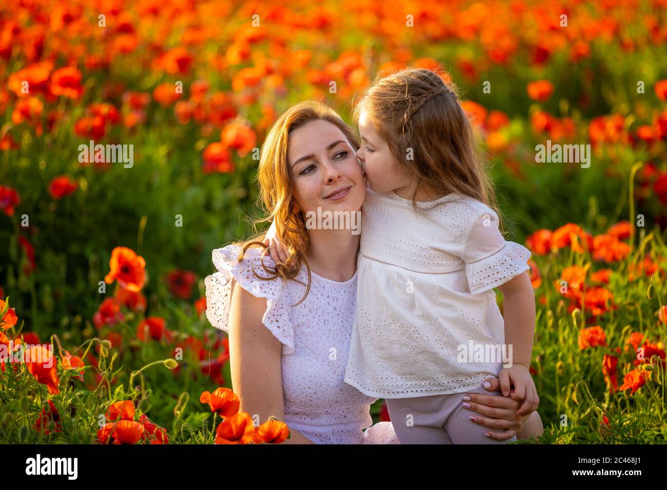 Belle mère et sa fille dans le champ de fleurs de pavot de printemps, république tchèque Banque D'Images