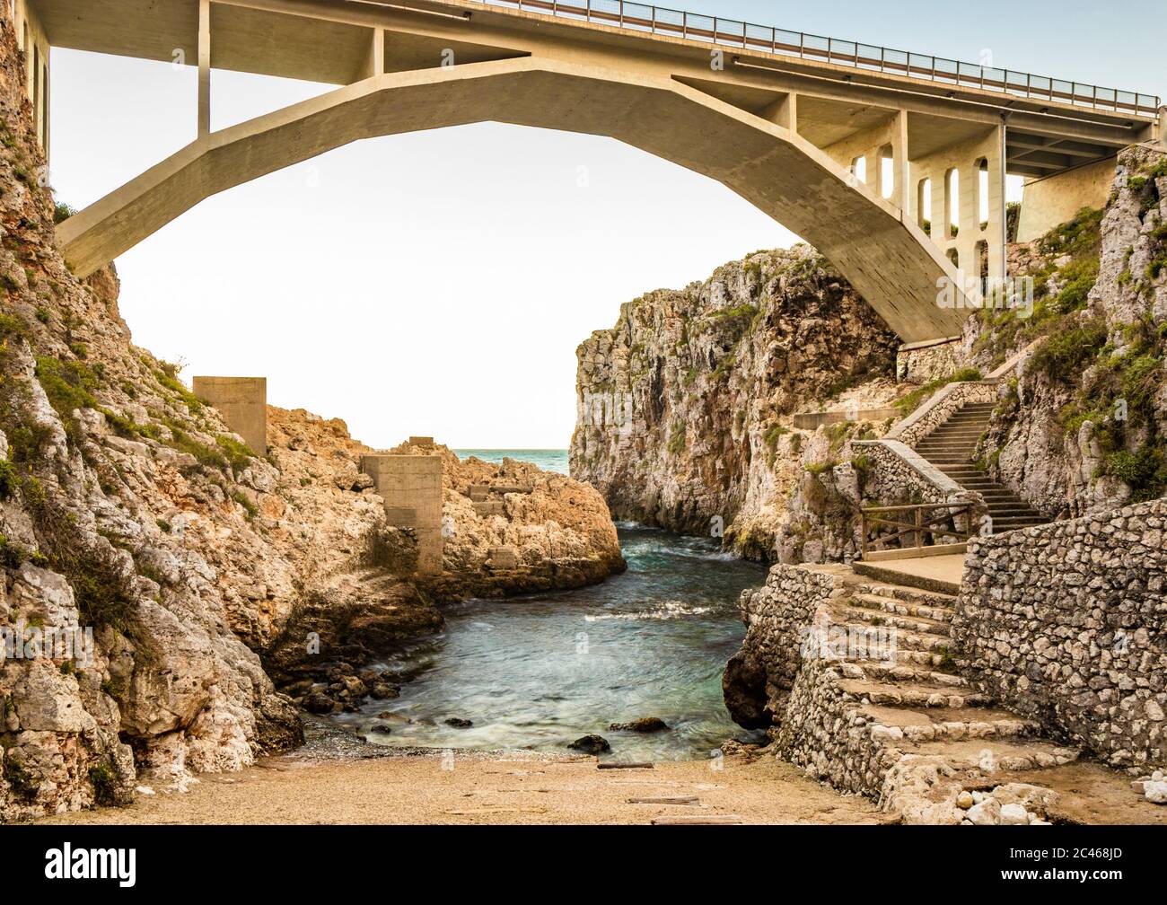 Le pont Ciolo relie deux hautes falaises. Une entrée de mer, à Gagliano del Capo, près de Santa Maria di Leuca. Le coucher de soleil rouge et orange. Sur un winte Banque D'Images