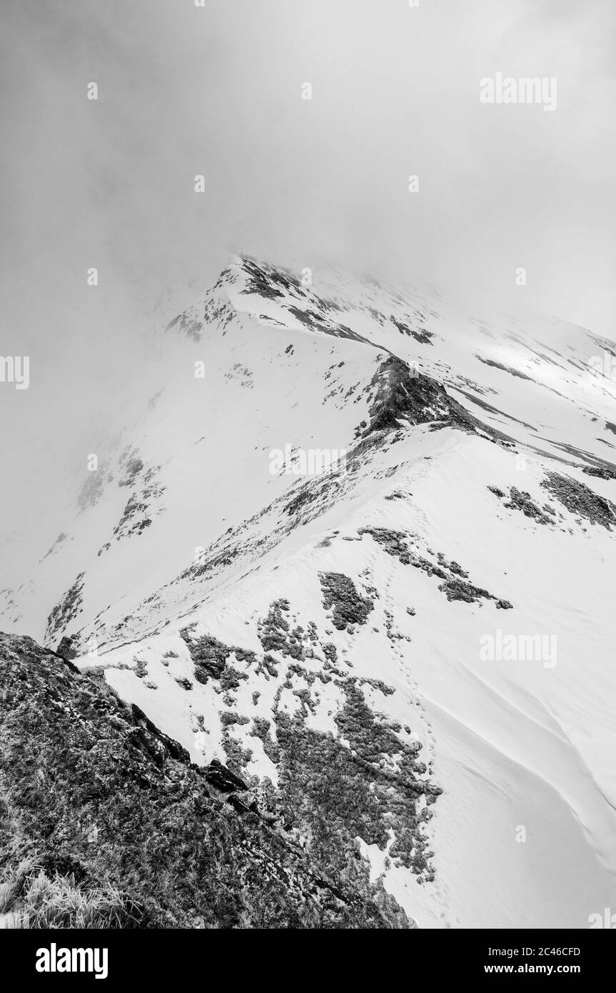 Empreintes de pas dans la neige pendant la randonnée sur la colline d'hiver sur la Brothers Ridge, Glen Shiel dans les Highlands écossais Banque D'Images