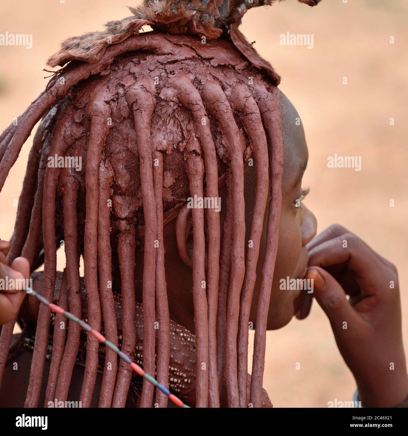 KAMANJAB, NAMIBIE - 1 FÉVRIER 2016: Jeune femme Himba non identifiée avec la coiffure typique montré en plein air Banque D'Images