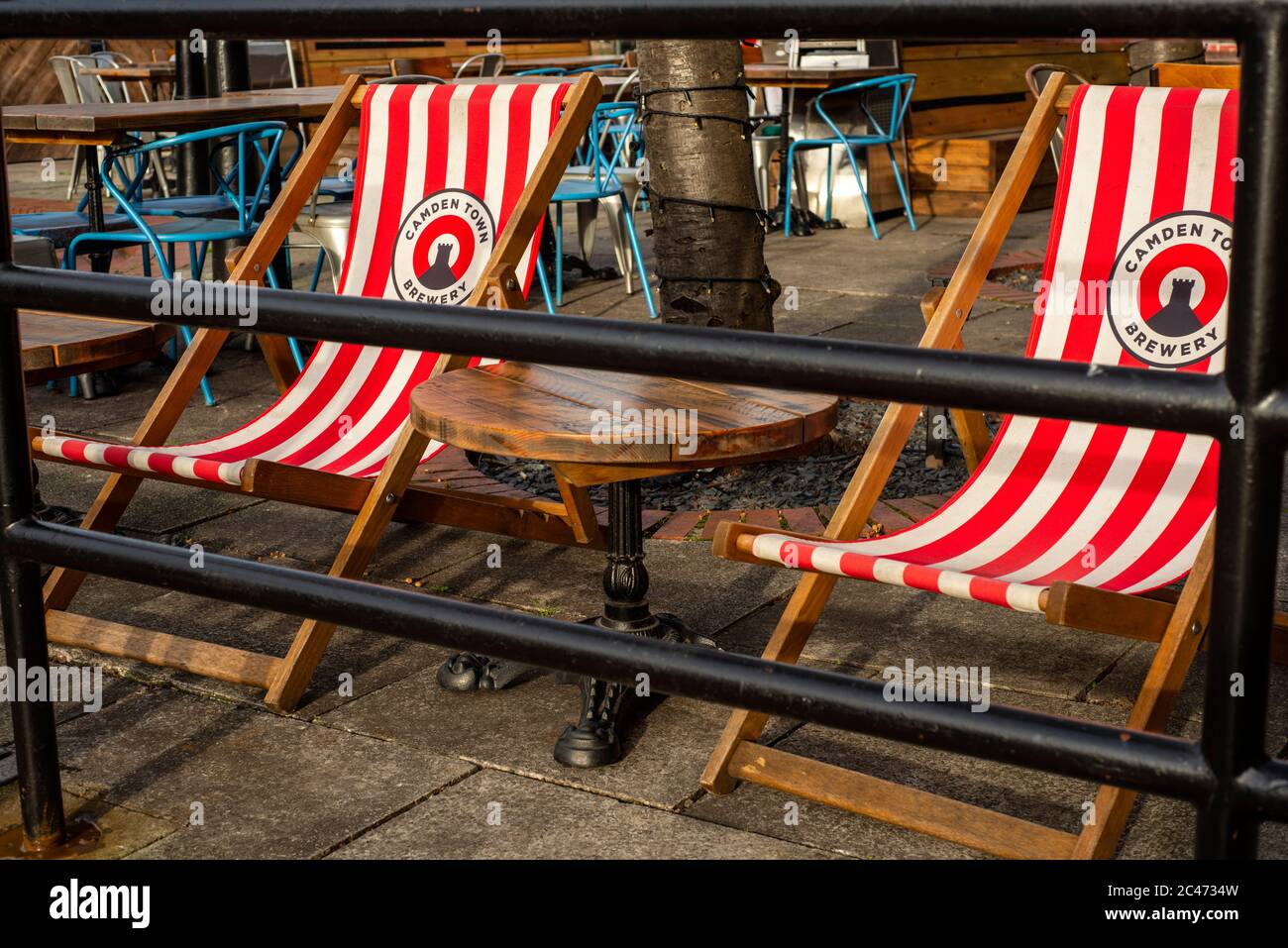 Logo de la brasserie de la ville de Camden sur les chaises longues ou les chaises longues rouges et blanches dans le jardin vide Anchor Pub sur la South Bank Londres Royaume-Uni Banque D'Images
