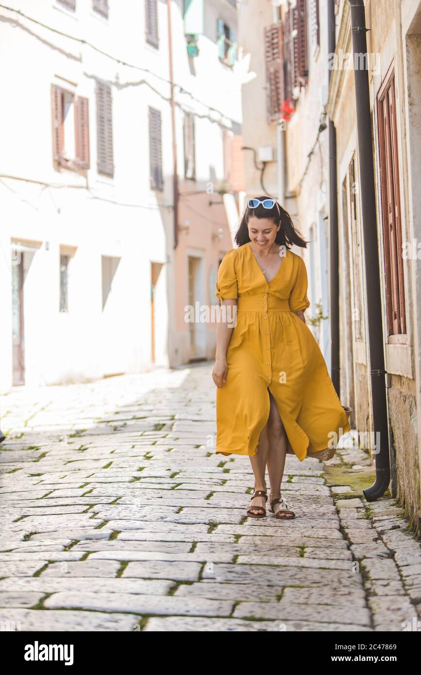 femme en robe jaune avec un chapeau de paille de bit marchant dans la  vieille ville touristique en croatie Photo Stock - Alamy