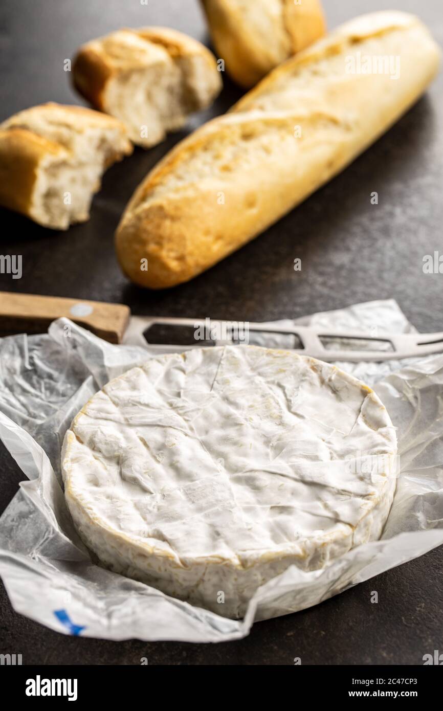 Fromage Brie. Fromage blanc doux avec moule blanc et baguette sur la table de cuisine. Banque D'Images