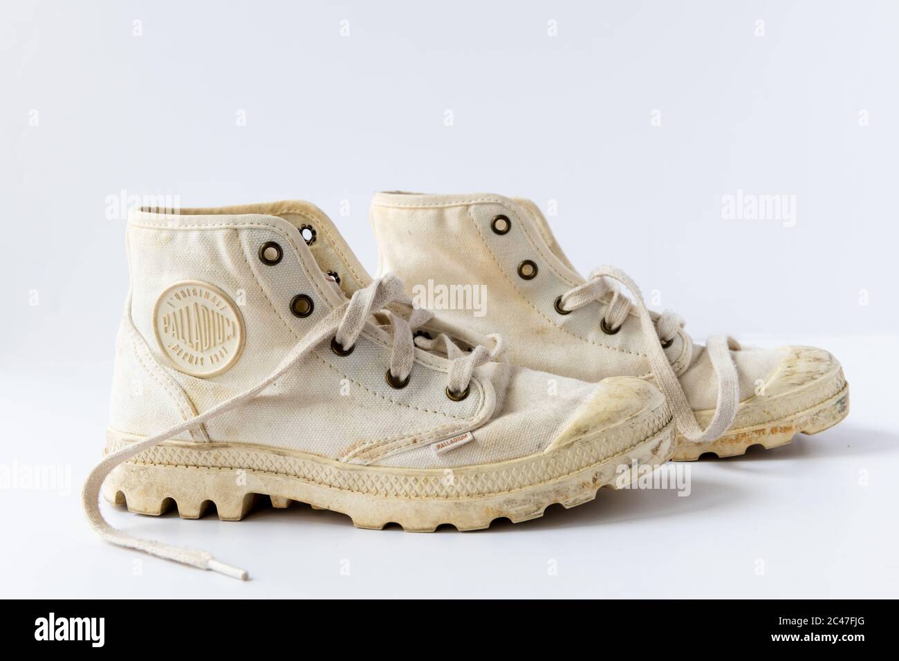 Une paire de bottes supérieures en toile blanche utilisées isolées sur un fond blanc. Banque D'Images