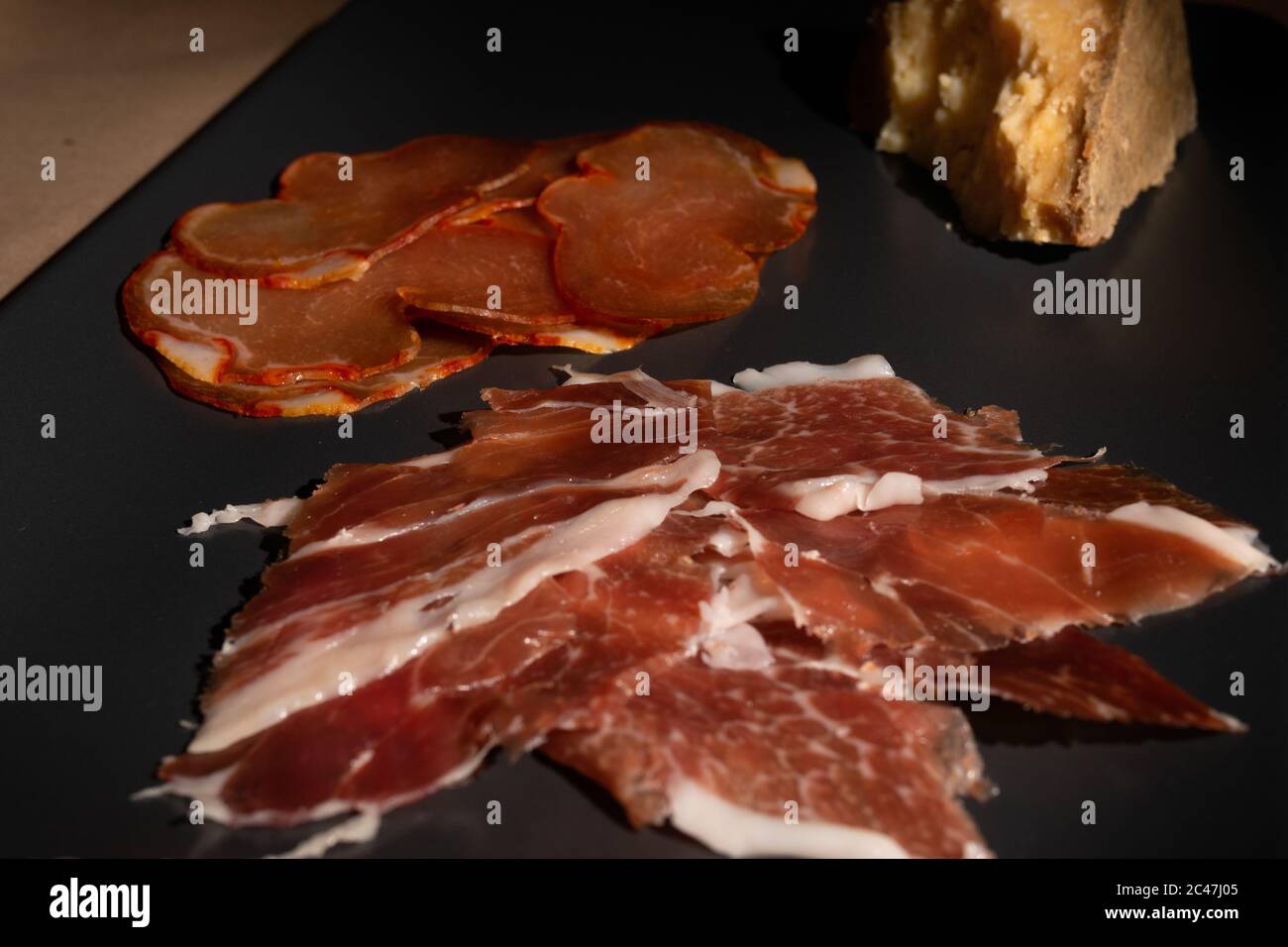 Gros plan de viande de porc fine en tranches avec une tarte sur une plaque noire Photo Stock Alamy