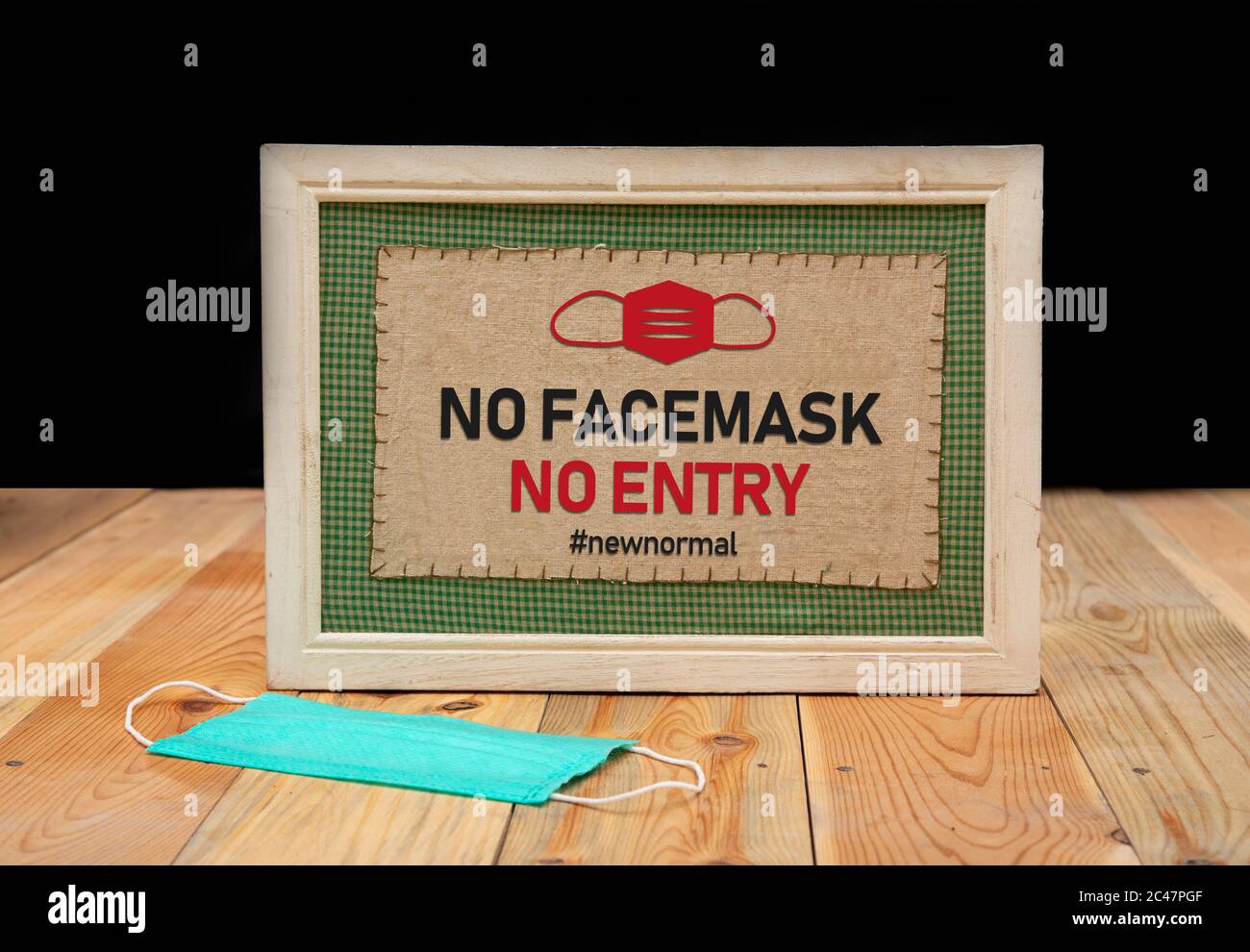 Pas de service sans masque facial - nouveau panneau normal sur la table en bois. Vie post-pandémique. Banque D'Images
