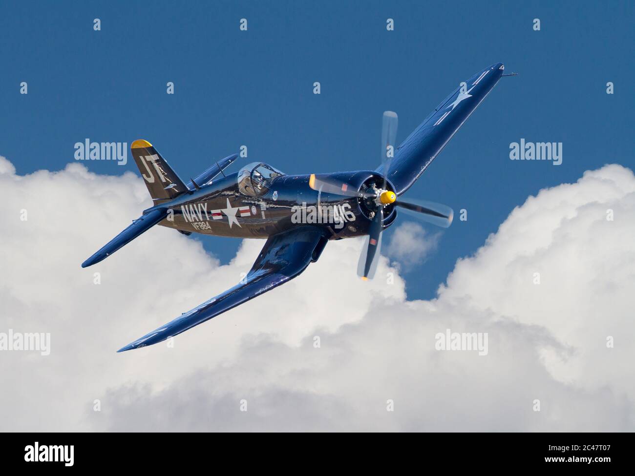 Un avion de chasse Corsair Vought F4U datant de la Seconde Guerre mondiale survolant les nuages dans un ciel bleu profond. Banque D'Images