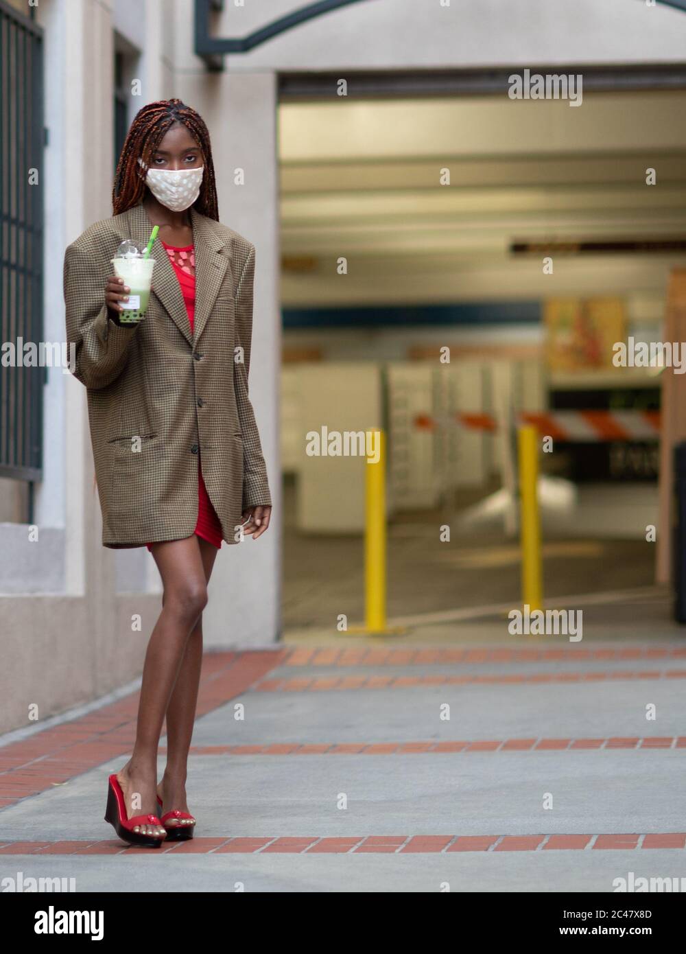 Jeune fille à peau foncée portant un masque facial en tissu protecteur en cas de pandémie de coronavirus, COVID-19. Banque D'Images
