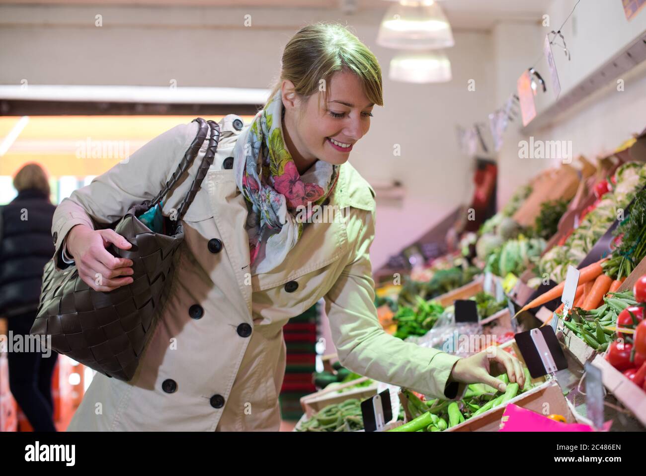 Photo de femme au marché acheter des légumes Banque D'Images