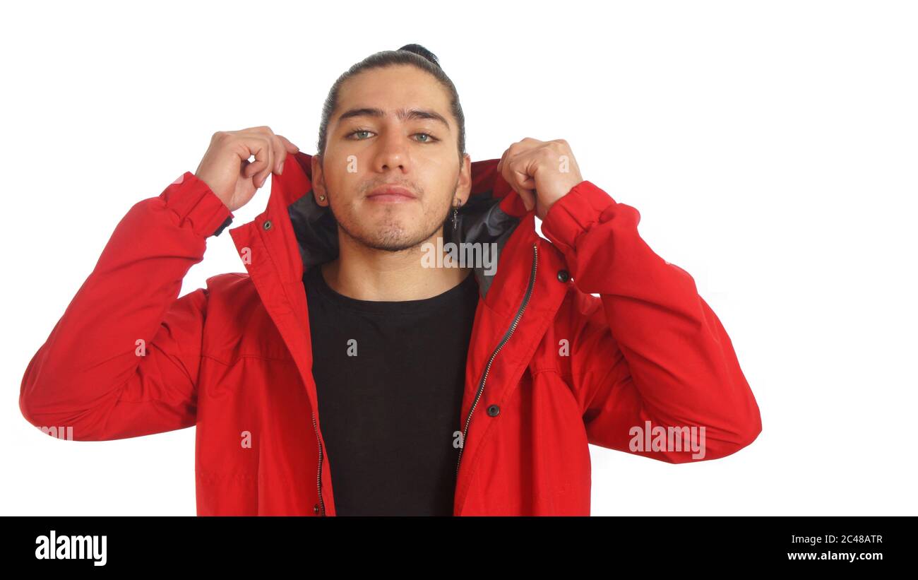 Jeune hispanique avec les cheveux froncés fait noeud portant le t-shirt noir et la veste rouge, posant devant la caméra sur fond blanc Banque D'Images